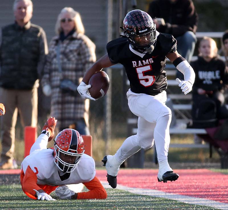 Glenbard East's Amonte Cook (5) slides up the sidelines past a Normal's Jackson Eimer (2) during the IHSA Class 7A quarterfinals Saturday November 11, 2023 in Lombard.