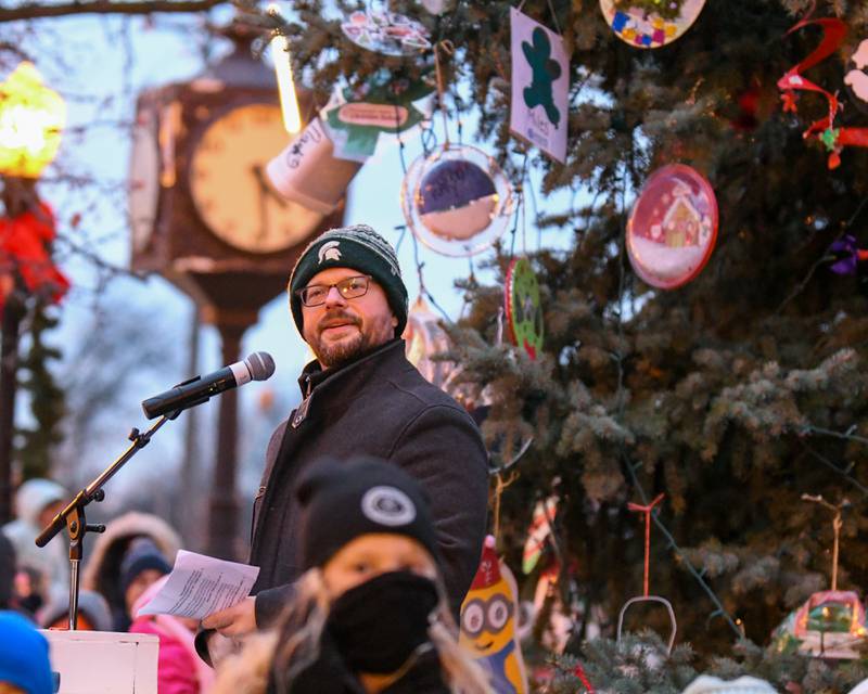 Downers Grove Mayor Pro Tem Greg Hose introduces the Downers Grove South Marching bad as they perform songs during the Christmas tree lighting ceremony on Friday Nov. 29, 2024, held in downtown Downers Grove.