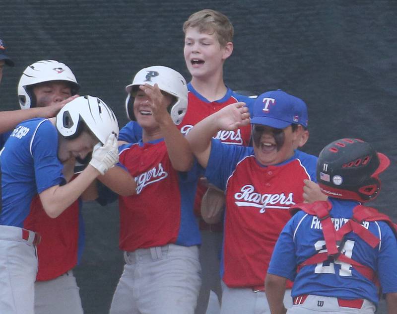 Members of the Frostbyte MSP Rangers react with teammate Mason Mucci after hitting a solo home run during the Ottawa Little League baseball (12U) City Championship on Friday, June 23, 2023 at Varland Park in Ottawa.