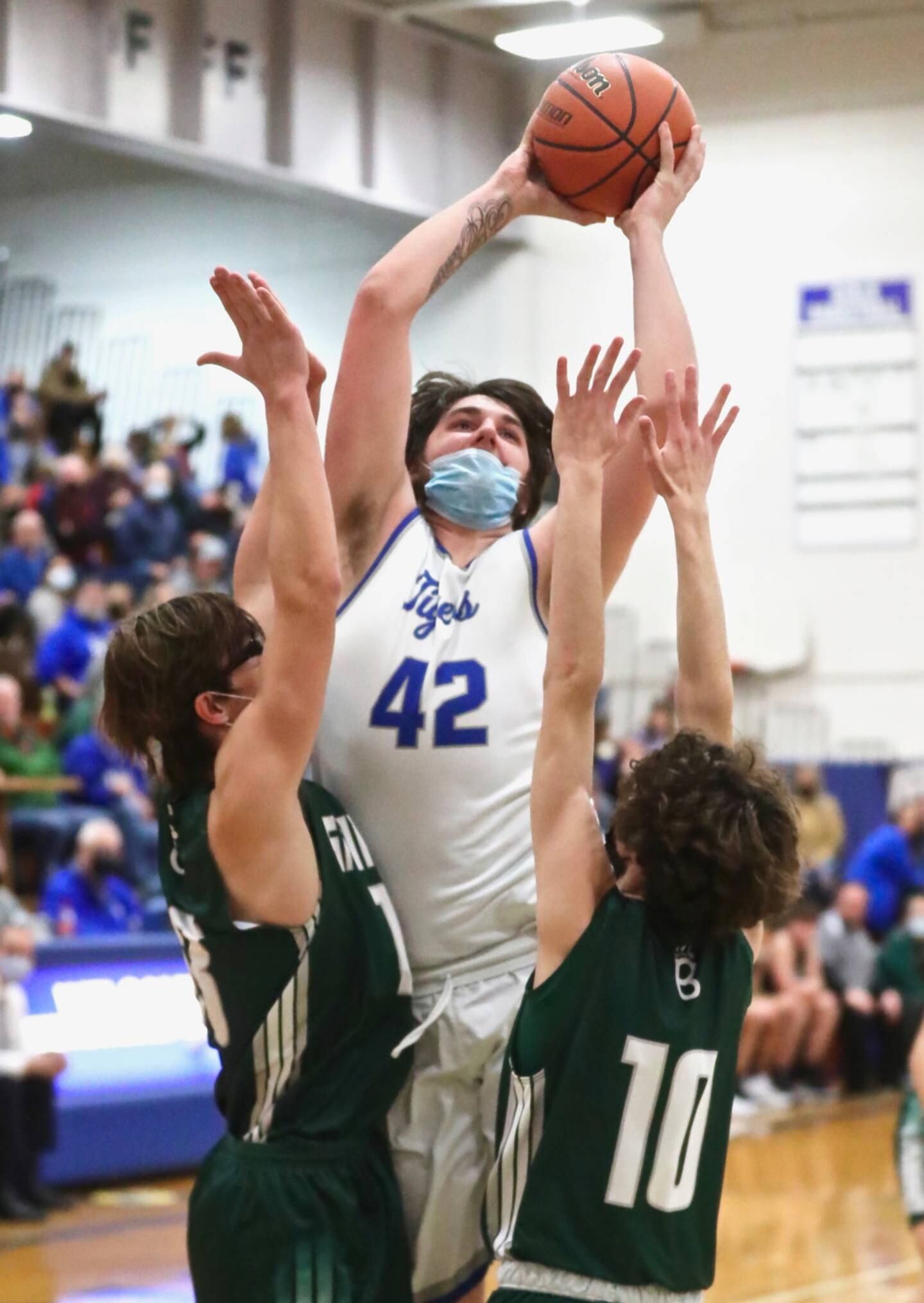 PHS senior Kaden Monroe muscles up for a shot over St. Bede's Landon Jackson (left) and Duncan Lawler Friday night at Prouty Gym.