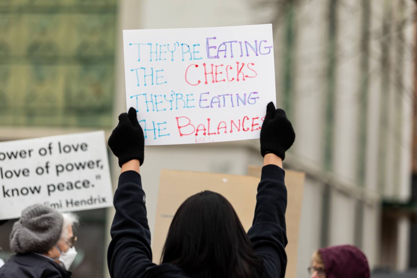 An attendee holds up a sign at the Hands Off protest in downtown Joliet on Saturday, April 5, 2025. The rally was part of a nationwide movement to protest policies and actions of the Trump administration and Elon Musk on Saturday.