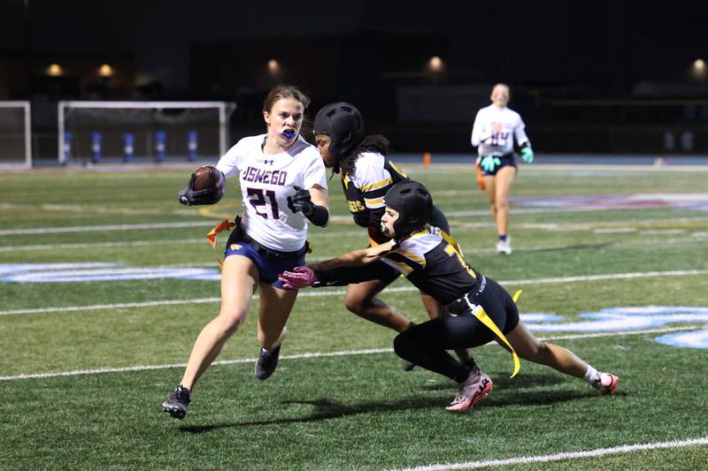 Oswego's Leona Bateman runs the ball as Joliet West's Mallory Crisafulli, front, and Kay Sowatey reach for her flags during the Panthers' 13-7 victory over Joliet West on Tuesday, Oct. 7, 2025.