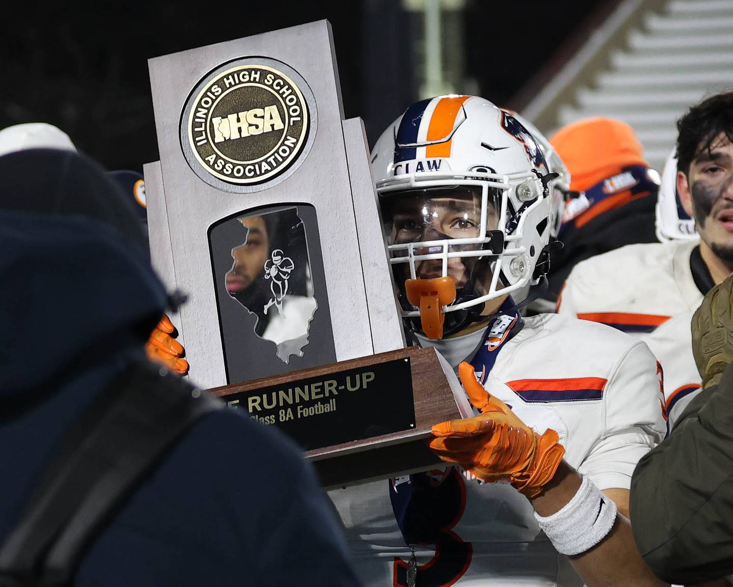 Oswego's Devin Mata holds the state runner-up trophy Wednesday, Dec. 3, 2025, after their loss to Mount Carmel in the IHSA Class 8A state chamionship game in Huskie Stadium at Northern Illinois University in DeKalb.