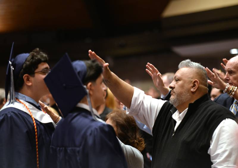 Family members of the Nazareth graduating class including Alex Aguirre of Lyons raise their arms in prayer and blessings during the mass and graduation held on Sunday, May 18, 2025 at Christ Church of Oak Brook.