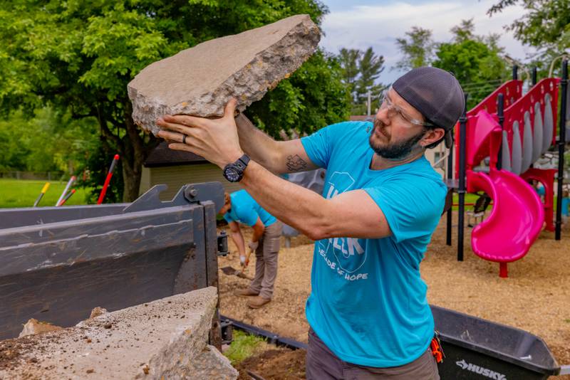 Keaton Settlemeyer throws a chuck of concrete into a hopper after it was removed from under the shelter at Ray Barto Memorial Park on June 3, 2025 in Seatonville.