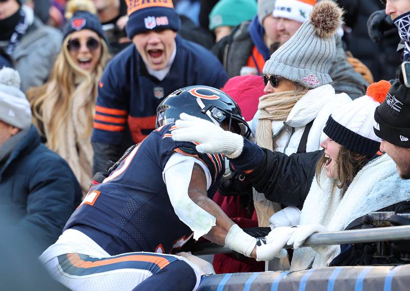 Chicago Bears running back David Montgomery jumps into the stands after scoring a touchdown during their game against the Eagles Sunday, Dec. 18, 2022, at Soldier Field in Chicago.