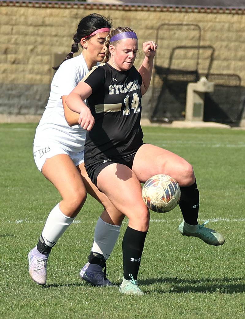 Sycamore's Peyton Wright tries to hold off Kaneland's Corinne Faivre during their game Monday, April 14, 2025, at Sycamore High School.