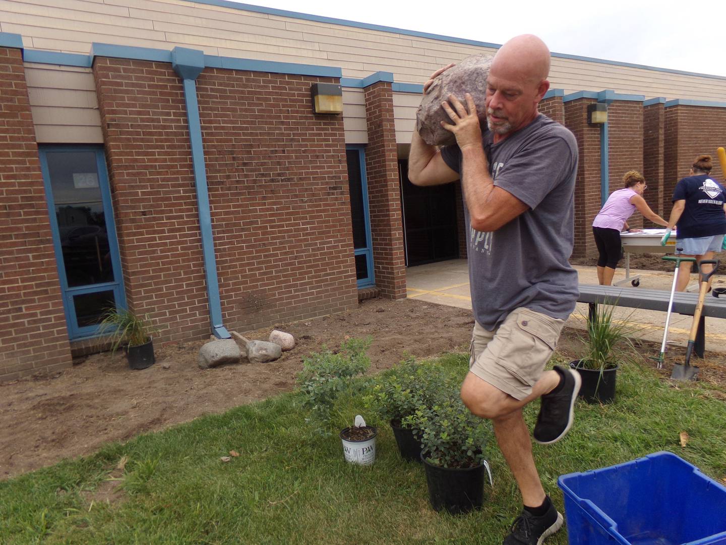 Volunteer Jim Pellino moves one of the donated stones Friday, Aug. 12, 2022, at Centennial School in Streator.