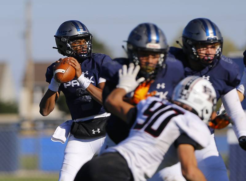 Oswego East's Tre Jones looks for a receiver during the varsity football game between Plainfield North and Oswego East on Saturday, October 23, 2021 at Oswego East high school in Oswego, IL.