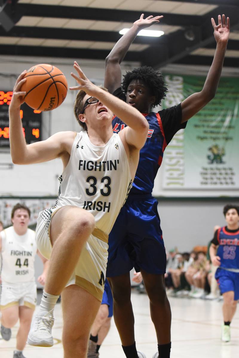 Bishop McNamara's Callaghan O'Connor, left, goes for a layup as Lycee Francais de Chicago's Sidy Doumbouya looks to block from behind during a game at Bishop McNamara Wednesday, Feb. 18, 2026.