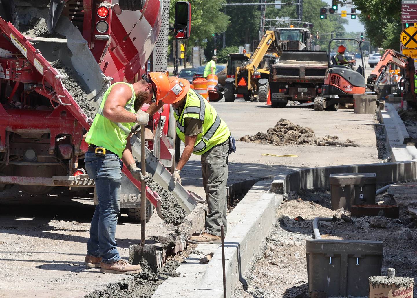 Workers pour concrete on the south side of Lincoln Highway near Second Street Wednesday June 29, 2022, in DeKalb. Construction is ongoing on Lincoln Highway between First and Fourth Streets.