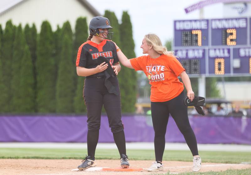 Beecher's Allie Johnson is congratulated at first base by assistant coach Margaret Landis during Beecher's 14-6 victory over Manteno in the Class 2A Manteno Regional championship on Friday, May 22, 2026.
