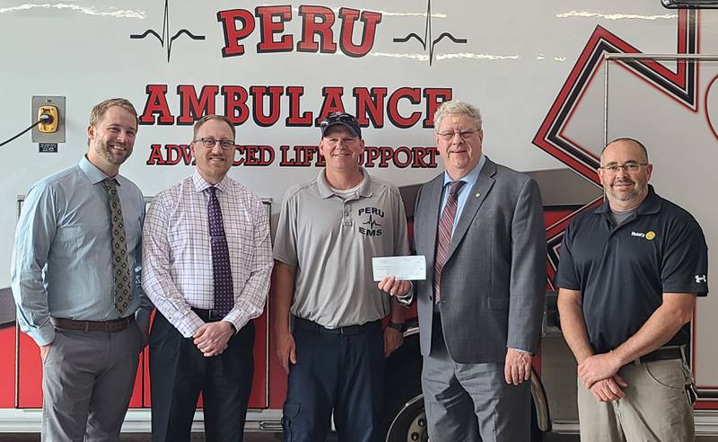 (From left) Doug Schweickert’s sons Scott and Steve (an Illinois Valley Sunrise Rotarian), Peru Volunteer Ambulance Service Director Brent Hanson, Sunrise President J. Burt and Sunrise Rotarian Rich Ploch are on-hand for a $2,000 donation made in memory of Douglas Schweickert to the Peru ambulance service.