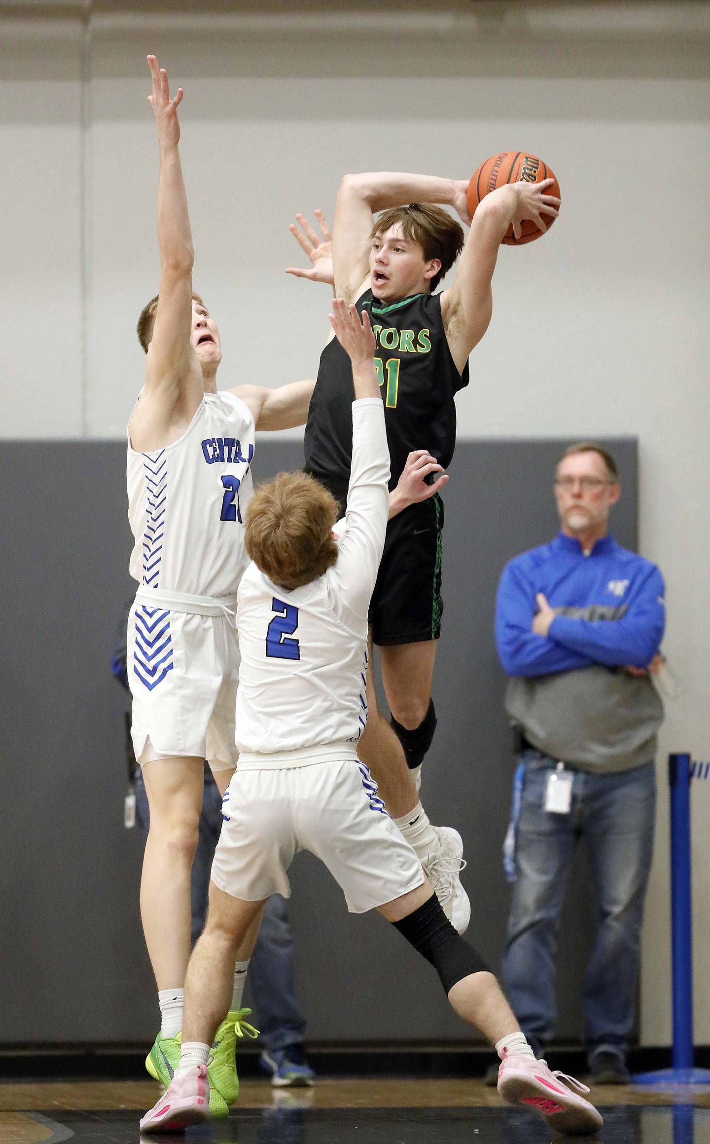 Crystal Lake South's Cooper M LePage (21) passes over Central's Andrew Scharnowski (21) and Nolan Milas (2)  Friday February 10, 2023 in Burlington.