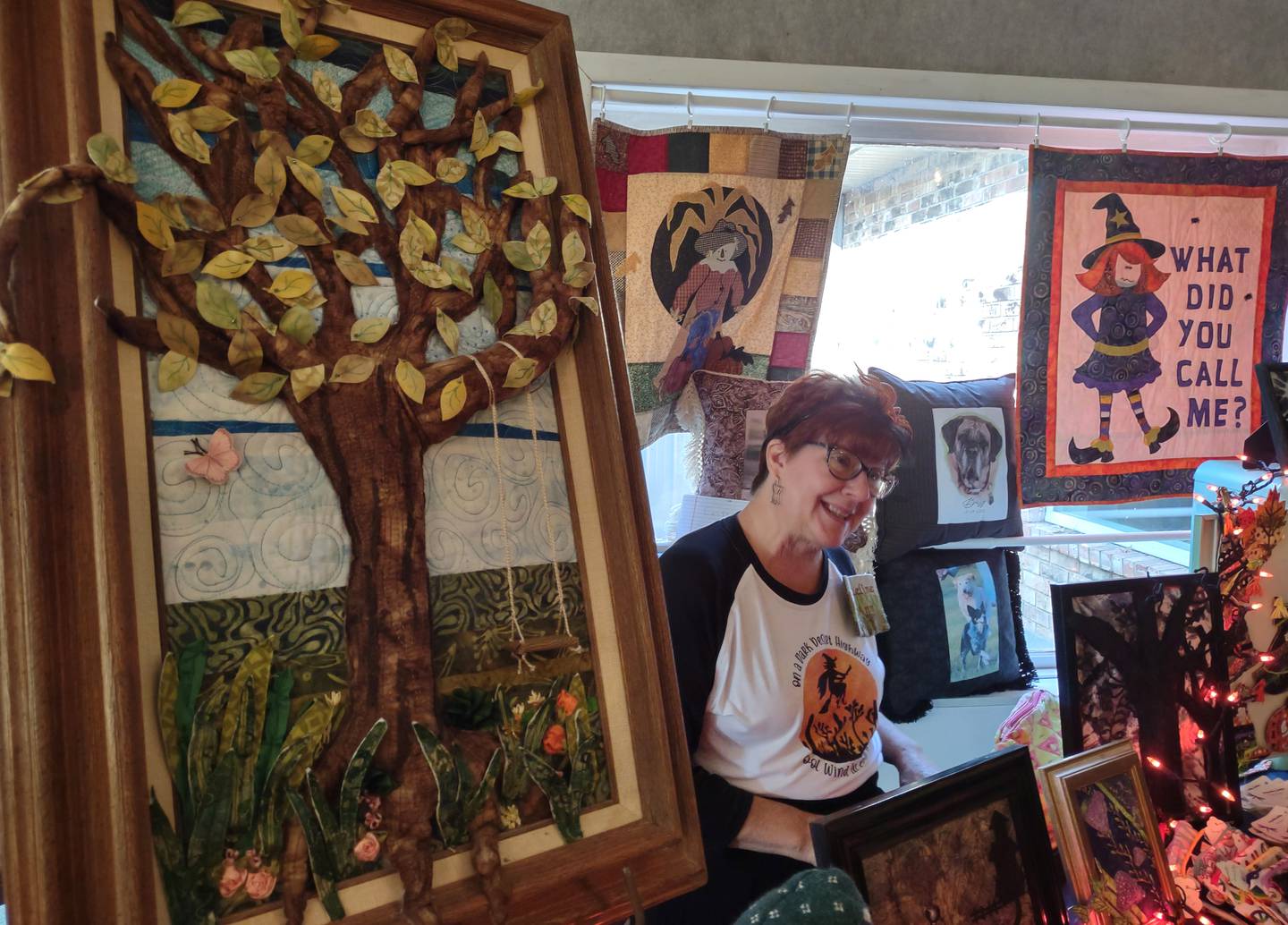 Jacqueline Hughes, a fiber artist from Ottawa, explains the process to create her three-dimensional quilted tree Saturday, Oct. 22, 2022, during the Witches Day Out market at Pitstick Pavilion in Ottawa.