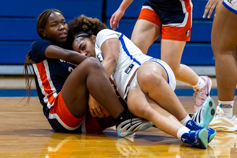Romeoville's Jamiah Player and Joliet Central's Melani Tua-Link fight for control of the ball during a varsity girls basketball game at Joliet Central on Dec. 18, 2025.