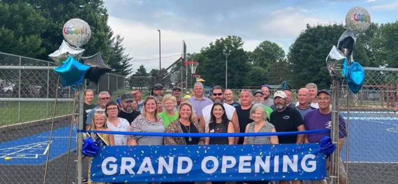 Current and past members of the Wyanet Community Club, former Wyanet High School basketball players and town board members and the mayor take part in the grand opening for the new flex courts at Memorial Park in Wyanet.