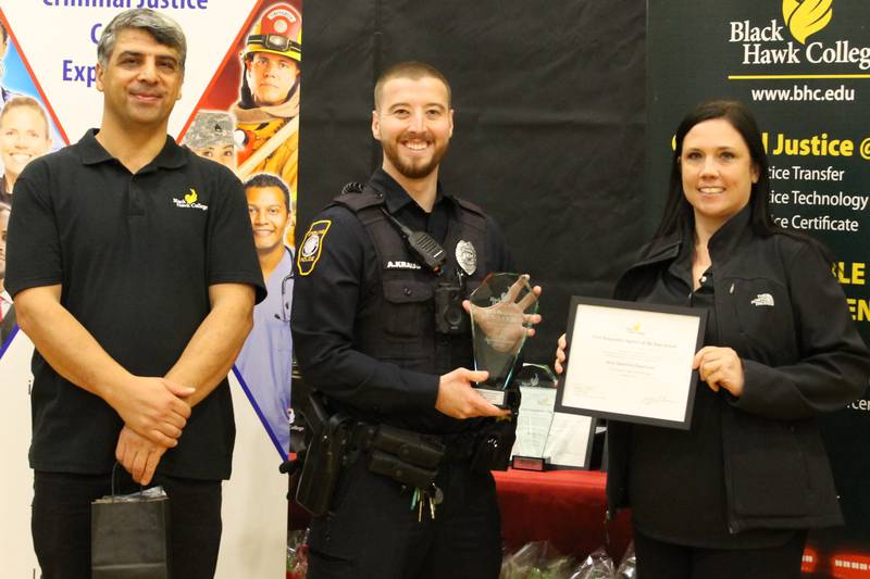 Sterling Police Officer Alex Kraus (center) holds his First Responder Award that was presented to him Friday by Dr. Seref Onder (left), director of Black Hawk College Criminal Justice Program, and Samantha Gange, member of the Black Hawk College Board of Trustees.