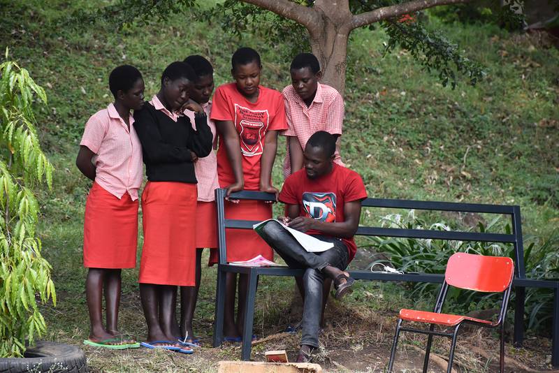 Students from the Jane Adeny Memorial School for Girls gathering around their teacher for a class meeting.