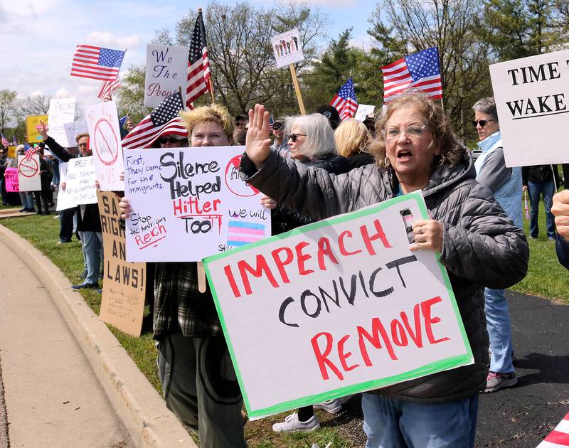 Protesters wave at honking cars on Sycamore Road Saturday, May 3, 2025, at Hopkins Park in DeKalb during a May Day Rally for Democracy to protest against Trump administration policies.