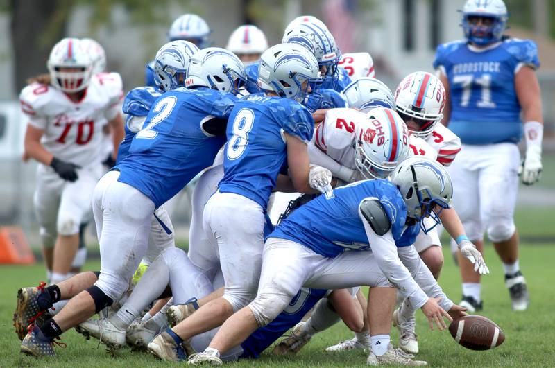 Woodstock’s Jackson Canty scoops up a loose ball against Ottawa in varsity football at Larry Dale Field on the campus of Woodstock High School Saturday.