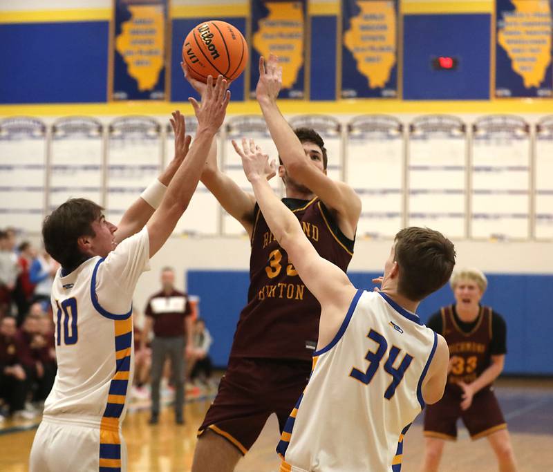 Richmond-Burton's Jace Nelson (center) drives to the basket between Johnsburg's Zack Willis (left) and Danny Loud (right) during the IHSA Class 2A Johnsburg Regional Championship boys basketball game on Friday, February, 27, 2026, at Johnsburg High School.