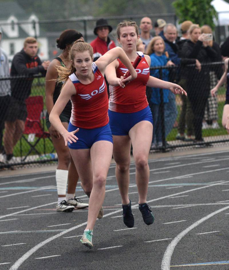 Oregon's Lexi Ebert hands the baton to Miranda Ciesiel in the 4x200 relay at the 1A Winnebago Sectional on Friday, May 12.