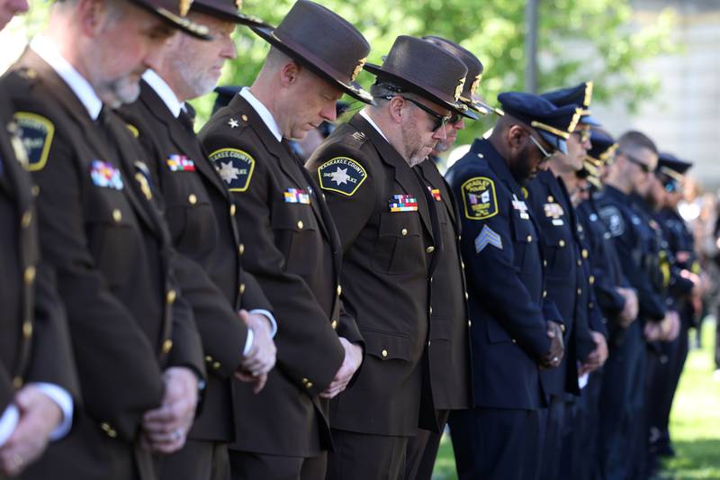 Members of local police departments bow their heads in prayer during the Kankakee County Law Enforcement Memorial on Thursday, May 14, 2026, at the Kankakee County Courthouse.