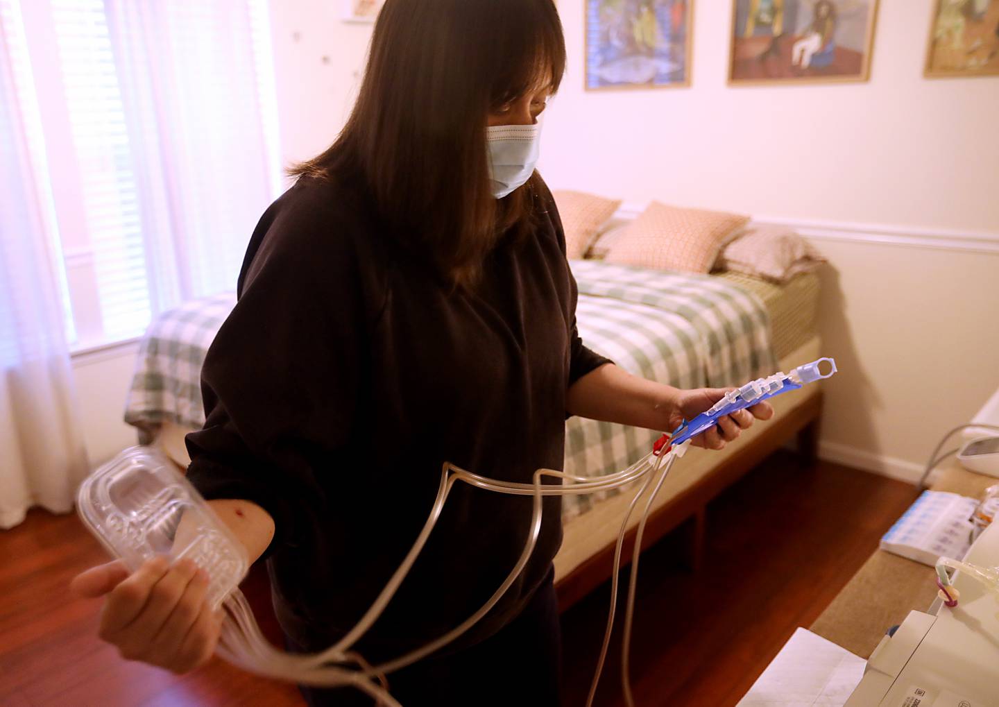 Nicole Leonard, 32, of Lakemoor, hooks herself up to a Peritoneal dialysis machine on Thursday, Aug. 14, 2025 at her home in Lakemoor. She  was diagnosed with kidney disease in 2022 and has created a website and flyers in an attempt to find a living kidney donor.