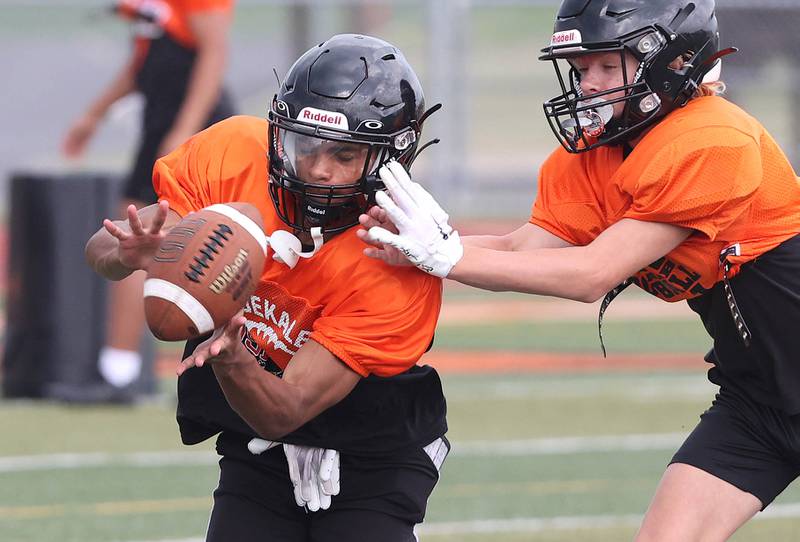 DeKalb’s Xavier Dandridge (left) makes a catch during practice Wednesday, July 12, 2023, at the school.
