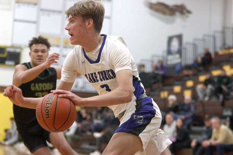 Lake Zurich’s Kain Kretschmar drives with the ball in Hinkle Holiday Classic boys basketball tournament game action at Jacobs High School Wednesday.