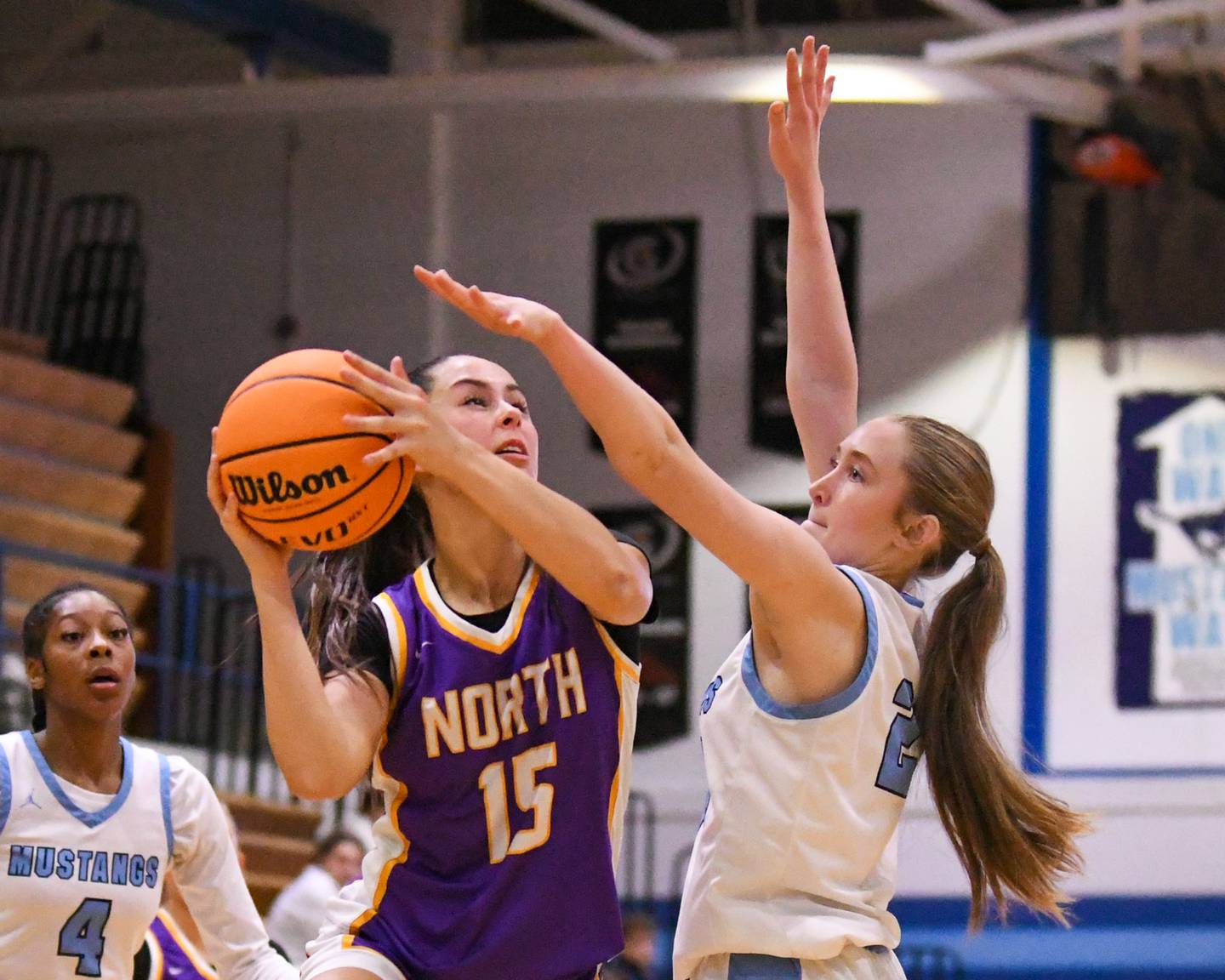Downers Grove North's Adysen Fanta (15) takes a shot while being defended by Downers Grove South's Mia Orde (24) during the game on Saturday Dec. 21, 2024, held at Downers Grove South High School.
