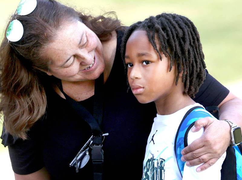 Lincoln Elementary School Principal Jennifer Tallitsch greets third grader Kodii Saunders as he arrives for the first day of classes Wednesday, Aug. 14, 2024, at the school in DeKalb.