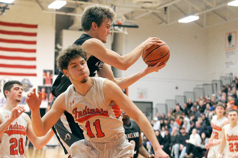 Kaneland's Parker Violett comes down with a rebound against Sandwich's Dyland Young (11) during a boys' basketball game at Sandwich High School on Friday, Jan. 13, 2023.