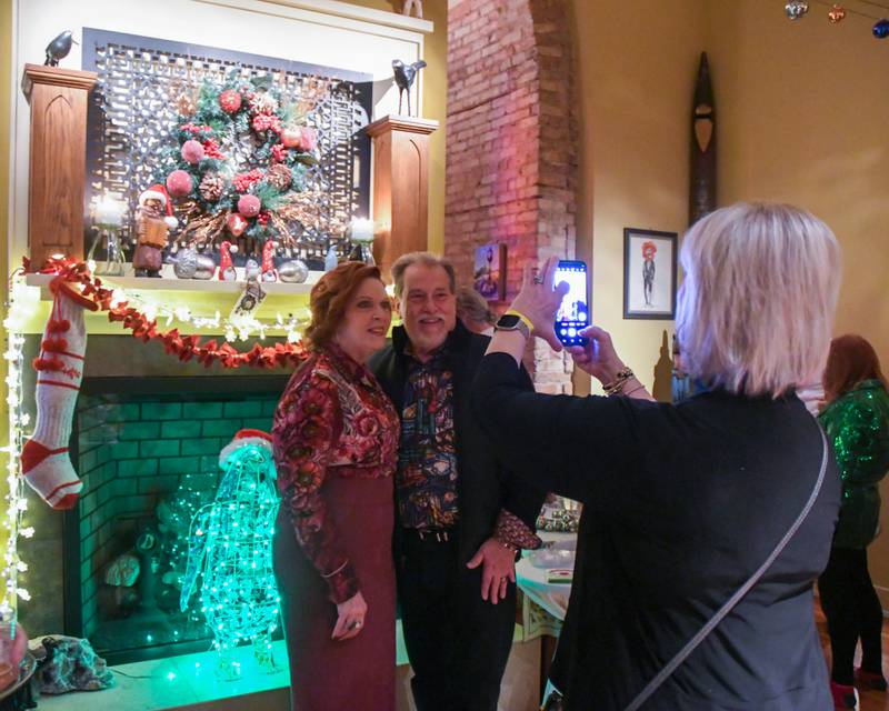 Mary Piette, fomer board member of the La Grange historical society and husband Tom Piette get their photo taken by Pam Peterson in front of the Padgett House fireplace during the Holiday Sip and Sweet Tour event held in La Grange on Sunday Dec. 17, 2023.