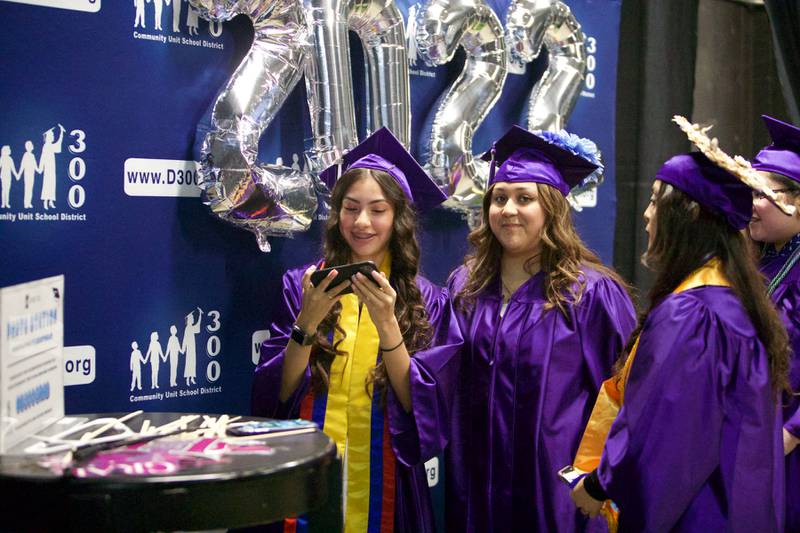Hampshire seniors take photos with friends before the Hampshire High School graduation ceremony on May 21, 2022, at the NOW Arena in Hoffman Estates.