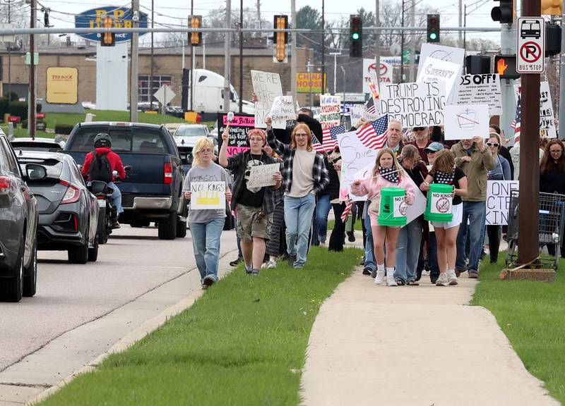 Protesters head north along Sycamore Road Saturday, April 19, 2025, during a “No Kings” rally and march that started at Hopkins Park in DeKalb. The group was protesting what they’ve argued is the unlawful and harmful federal policies of President Donald Trump and his administration.