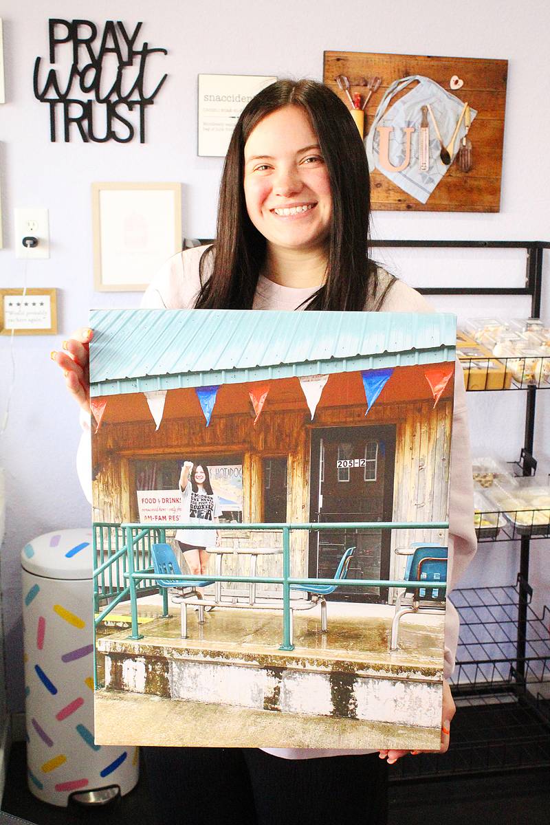 Hayley Rogers, owner of The Cookie Jar in downtown Amboy, shows a picture of her store when she first opened in Sept. 2024.