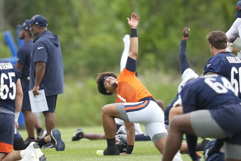 Chicago Bears quarterback Justin Fields stretches at the start of a training camp practice, Saturday, July 29, 2023, in Lake Forest.