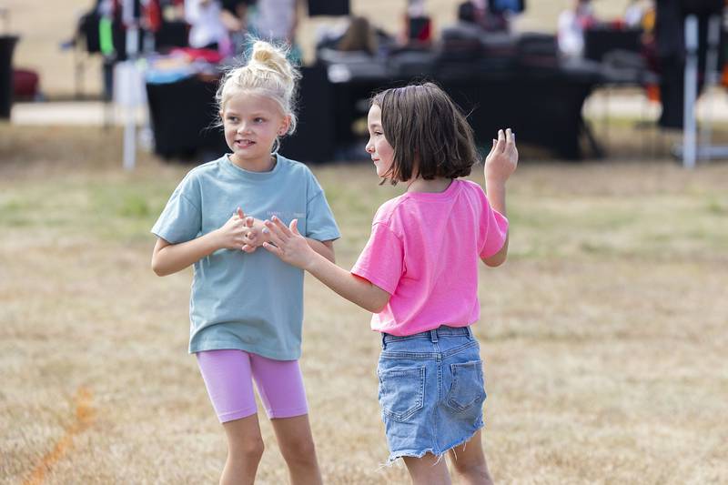 Marley Mekeel, 8, and Addy Wyckstandt, 7, dance to the music Saturday, Sept. 13, 2025, during Taste of Fiesta at RB&W Park in Rock Falls.