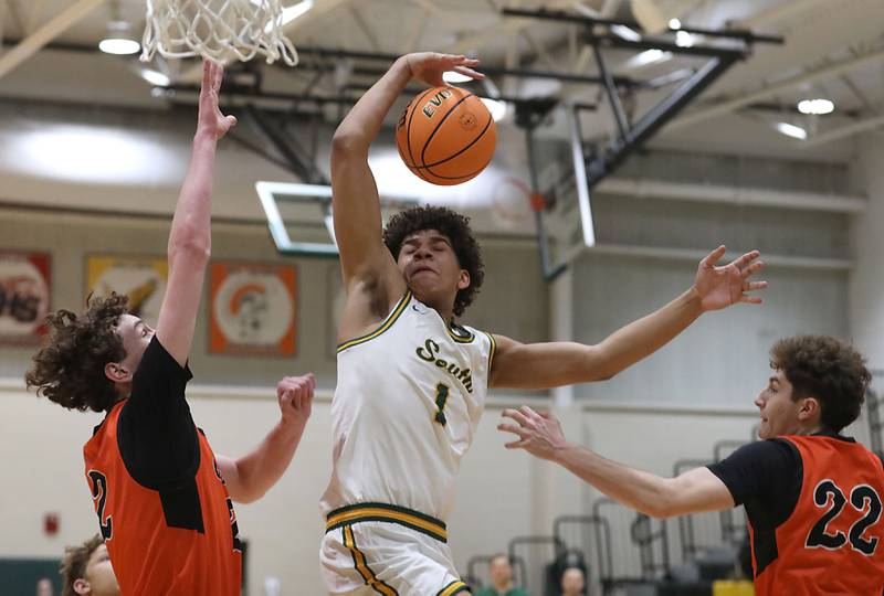 Crystal Lake South's Noah Cook looses the ball as he drives to the basket between \Crystal Lake Central's Danny Spychala (left) and Nick Stowasser (right) during an IHSA Class 3A Crystal Lake South Regional boys basketball semifinal game on Wednesday, February, 25, 2026, at Crystal Lake South High School.