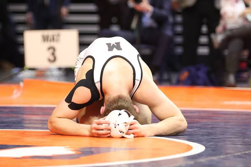 McHenry’s Chris Moore takes a moment on the mat after his loss to Mt. Carmel’s Colin Kelly in the Class 3A 160lb. championship match at State Farm Center in Champaign. Saturday, Feb. 19, 2022, in Champaign.