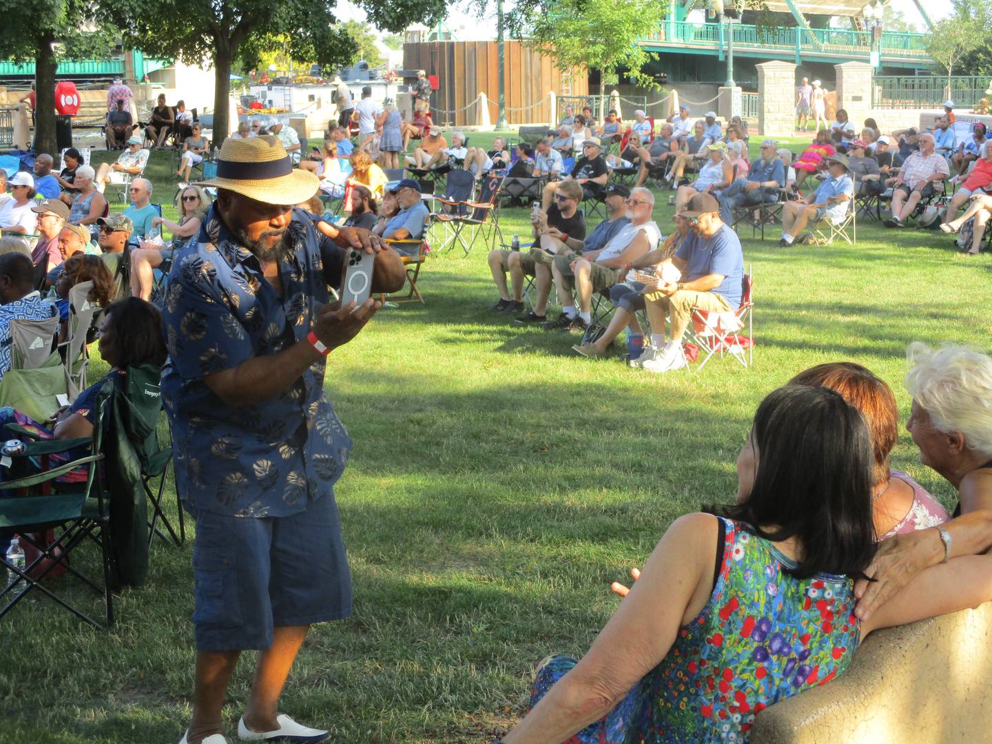 Al Howard of Joliet shoots a photo for a group of friends who came to the Joliet Blues Festival at Billie Limacher Bicentennial Park in Joliet on Saturday. Aug. 9, 2025