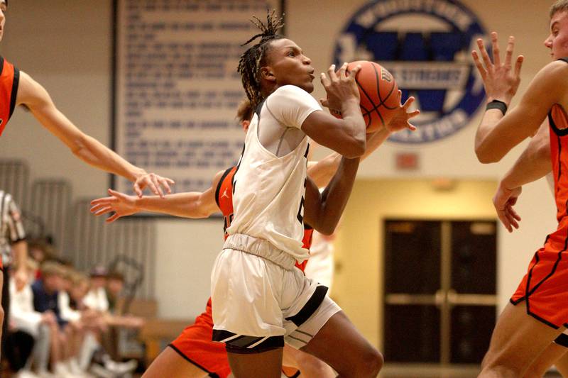 Kaneland’s Isaiah Gipson navigates traffic against McHenry in Hoops for Healing basketball tournament championship game action at Woodstock Wednesday.