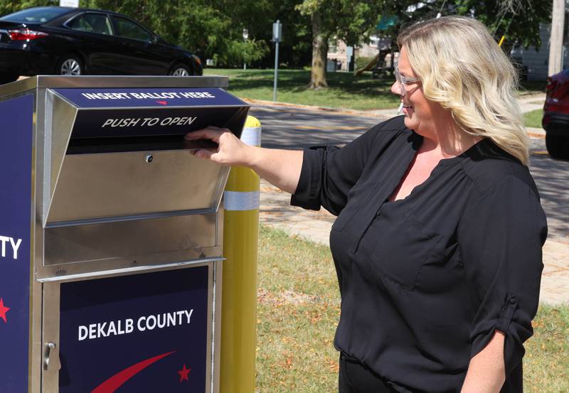 Tasha Sims, DeKalb County County clerk and recorder, demonstrates how to use the new ballot drop box Thursday, Sept. 26, 2024, outside the DeKalb County Administration Building in Sycamore.