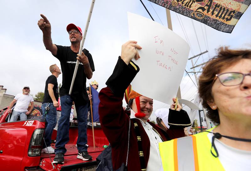 A Trump supporter yells as he counter protests from the bed of a pickup truck during a "No Kings” protest rally on Saturday, Oct. 18, 2025, along Route 31 in McHenry. This political event drew thousands of protesters to the area to voice their opinions about the policies of President Donald Trump. Photographing protests is always interesting. Most pictures are one sided, but successfully capturing both sides of a protest in a single image is always great.