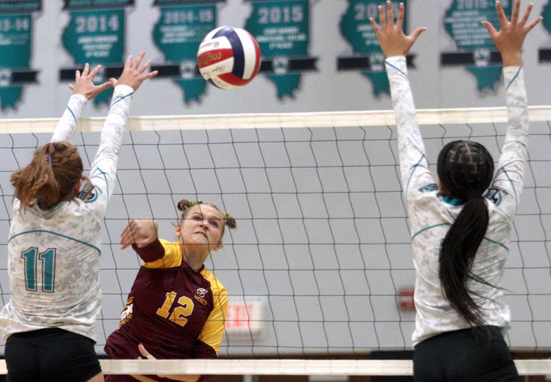 Richmond-Burton’s Zoe Freund, center, sends the ball over the net in varsity volleyball at Woodstock North Monday night.
