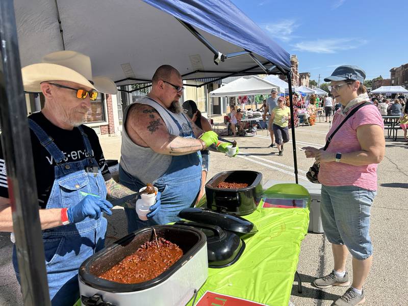 Kevin Randall (left) and Mark Pellini serve chili to Ellen Ebert of Polo at the annual chili cook off on Saturday, Sept. 27, 2025. Randall, Pellini, and Dave Witmer, all of Polo, had one of the booths at this year's event.