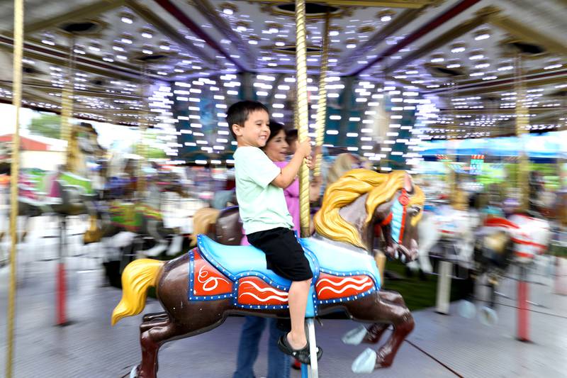 Jack McGregory, 6, of Pingree Grove rides a Merry-Go-Round with his grandma, Angie McGregory of Geneva and brother, Henry, 2, during the first day of the Kane County Fair on Wednesday, July 12, 2023.
