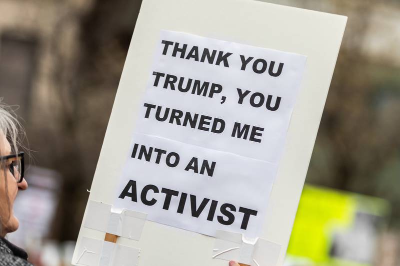 An attendee holds up a sign at the Hands Off protest in Downtown Joliet on April 5, 2025.